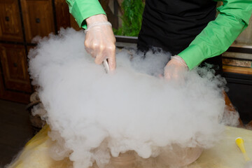 Making ice cream with liquid nitrogen. Show program of the chef for the holiday. Steam from a chemical reaction. Stunt.