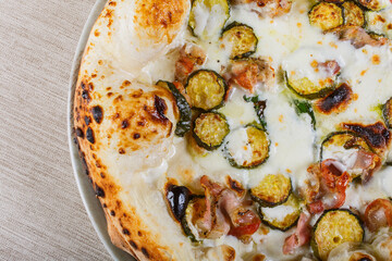 Pizza napoletana con mozzarella, zucchine e pancetta