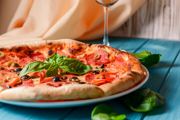 Fresh italian pizza with salami and black olives. Traditional Italian pizza recipe, Italian cuisine.