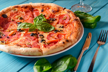 Fresh italian pizza with salami and black olives. Traditional Italian pizza recipe, Italian cuisine.