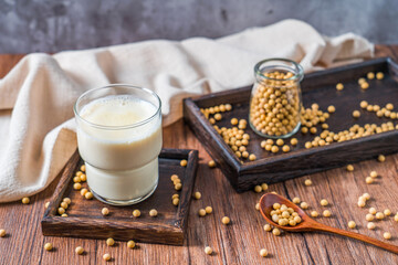 Many soybeans and a cup of soy milk on the bamboo mat