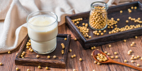 Many soybeans and a cup of soy milk on the bamboo mat