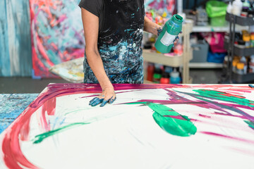 Woman artist painting with hands on canvas in workshop studio - Painter work and creative craft...