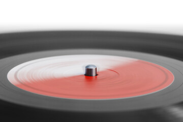 A part of spinning vinyl record on a turntable. Selective focus, photo in motion.