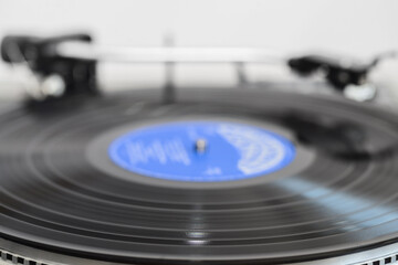 A spinning vinyl record on a turntable. The photo was taken in motion. Selective focus.