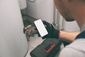White blank screen mobile phone in plumber's hand in protection gloves