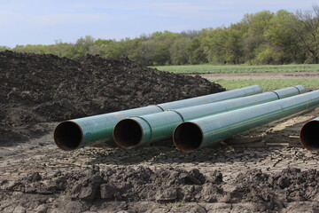 A Natural Gas pipe line in a farm field with dirt , blue sky and tree's west of Hutchinson Kansas...