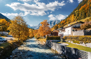Fototapeta na wymiar Stunning nature landscape. Beautiful colorful autumn scenery with a stream and forest. Amazing sunny day on the mountain river. concept of an ideal resting place. Parish Church of St. Sebastian