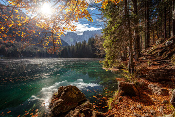Panele Szklane  Autumn nature landscape of mountain valley. Amazing Fusine lake with Picturesque sky in sunny day. Picture of wild area. Popular locations for travel and hiking. Concept of resting on outdoor.