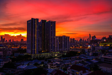Fototapeta premium The high angle background of the city view with the secret light of the evening, blurring of night lights, showing the distribution of condominiums, dense homes in the capital community