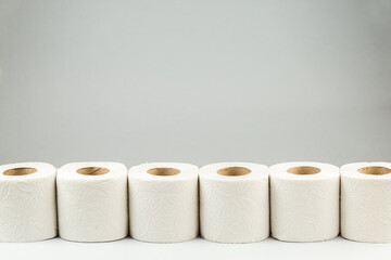 A Row of Toilet Paper Rolls on Gray Background