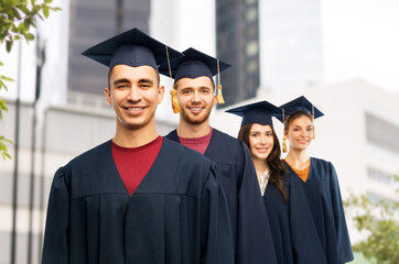 education, graduation and people concept - group of happy graduate students in mortar boards and...