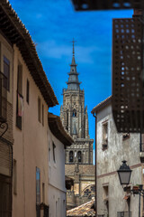 Fototapeta na wymiar View of a buildings in Toledo city downtown and Primate Cathedral of Saint Mary of Toledo tower as background