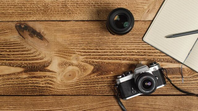 Top Down Shot of Person Placing SLR Camera On Table with Left Copy Space