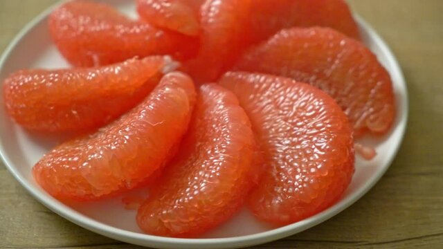 fresh red pomelo fruit or grapefruit on plate