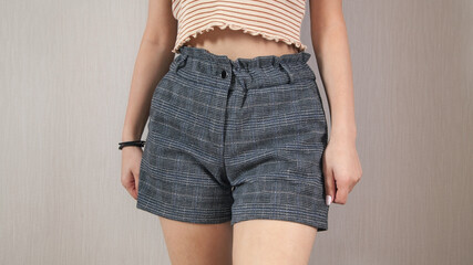  Young caucasian woman in fashion shorts at home.