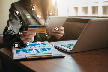 Businessman use credit card to shopping online in internet website shop with tablet and computer laptop on work table in office.