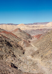The trail goes through a rocky desert canyon.