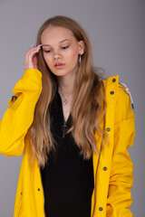 The girl in the yellow jacket straightens her hair and looks down. She thinks, ponders.