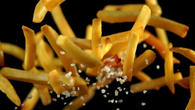 Super slow motion French fries with salt soars into the air. Filmed on a high-speed camera at 1000 fps.On a black background. 