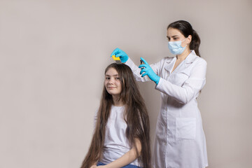 A dermatologist or trichologist applies a dandruff or lice weed to the patient's hair. Treating...