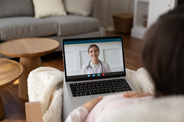 Fototapeta na wymiar Close up view over shoulder pregnant woman consulting with doctor therapist practitioner online at home, young future mom using laptop, involved in video call, pregnancy and telemedicine concept