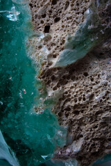 Textured stained glass rock detail. Abstract rocky coast from aerial view background