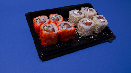 a small portion of rolls with fish on a pink background