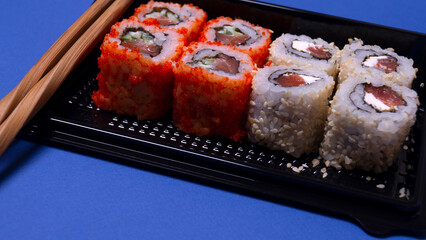 a small portion of rolls with fish on a pink background
