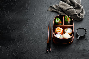 Japanese bento lunch box with chopsticks, on black stone background , with copyspace  and space for text
