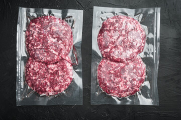 Vacuum beef cutlet sealed airtight pack, on black stone background, top view flat lay