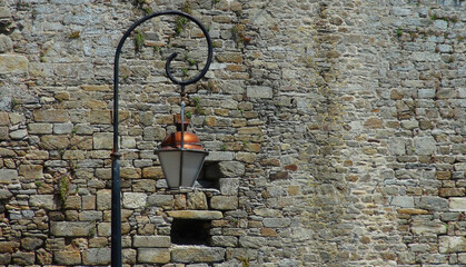 Fototapeta na wymiar a traditional street lantern, street light in front of a stone wall, St.Malo, France