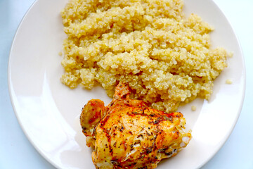 Top view of a plate with baked chicken and porridge. Healthy diet.