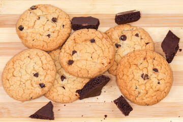 Chocolate chip cookies and porous chocolate pieces on cutting board