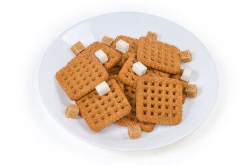 Flat square sugar shortbread cookies on dish and sugar cubes