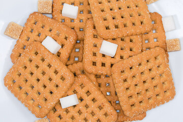 Flat sugar cookies and sugar cubes, top view close-up