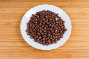 Breakfast cereal chocolate balls on dish on a wooden surface