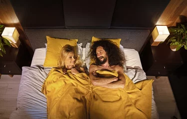 Foto op Canvas Young funny couple in a bed © konradbak