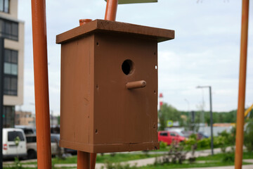 Brown wooden bird house in the city
