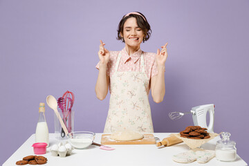Young housewife housekeeper chef cook baker woman in pink apron work at table kitchenware keep...