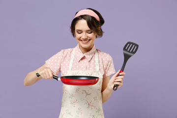 Young smiling happy cheerful housewife housekeeper chef cook baker woman in pink apron holding red...