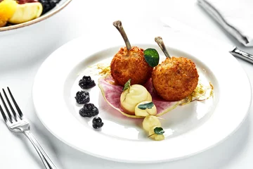 Tuinposter Two Chicken Kievs on a light plate, with potatoes and lettuce, author's serving of Kiev cutlets © Georgii