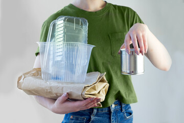 Woman holding capboard with Recyclable garbage consisting of glass, plastic, metal and paper. Eco volunteer