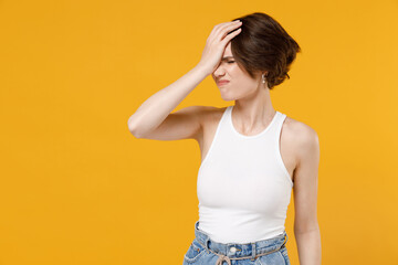 Young ashamed sad woman 20s with bob haircut wearing white tank top shirt put hand on face facepalm epic fail mistaken omg gesture isolated on yellow color background studio People lifestyle concept