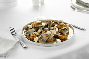 Salted herring with potatoes and onions on a large tablecloth, an appetizing plate with a classic Russian snack banquet serving