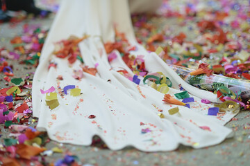 Wedding dress at the exit of the ceremony filled with confetti