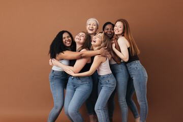 Six laughing women of a different race, age, and figure type. Group of multiracial females having fun against a brown background. - obrazy, fototapety, plakaty