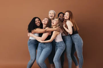 Fotobehang Six laughing women of a different race, age, and figure type. Group of multiracial females having fun against a brown background. © Artem Varnitsin