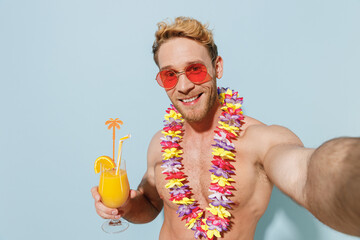 Handsome young sexy blond man in red shorts swimsuit glasses hawaii lei relax near hotel pool hold...