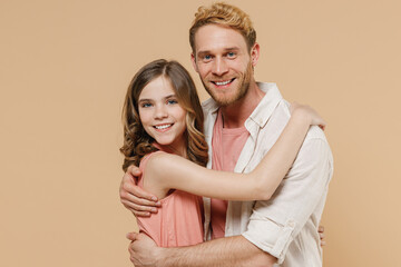 Young cool parent man have fun with cute child teen girl in casual pastel clothes. Daddy little kid daughter hug each other isolated on beige color background studio. Father's Day Love family concept.